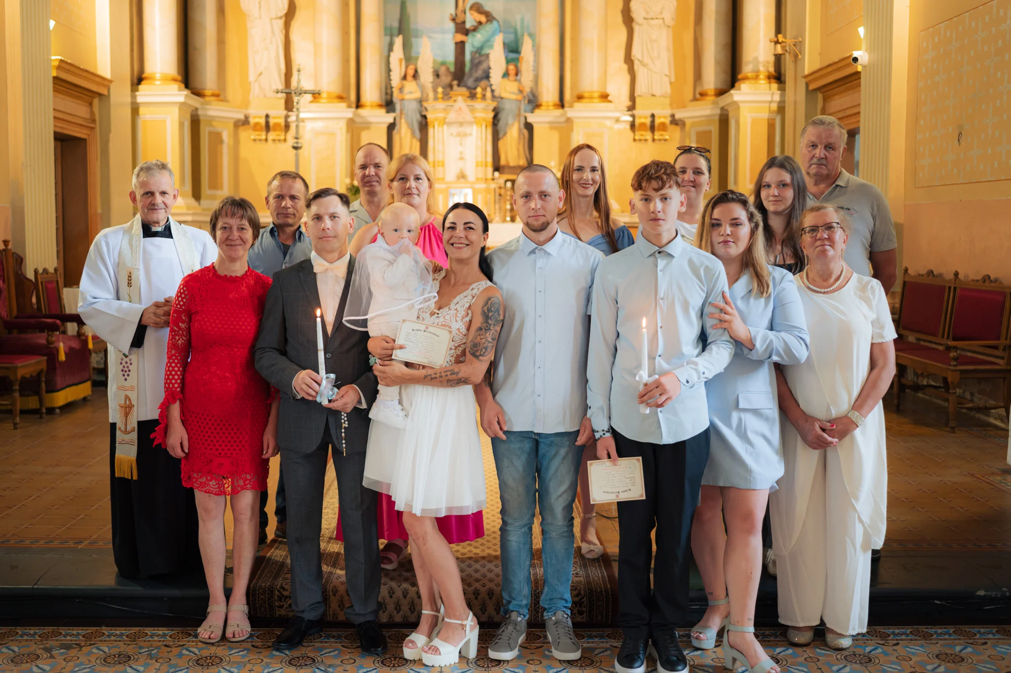 Šeimos fotografija prie bažnyčios krikštynų dieną Joniškyje